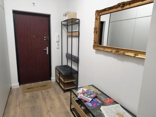 a hallway with a mirror and a door and a table at Century Apartment in Wrocław