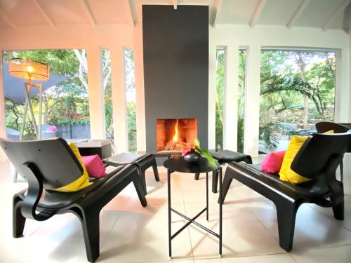 a living room with two chairs and a fireplace at Casa Bromélia in Palmeiras
