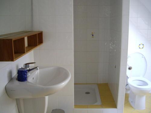 une salle de bain avec un lavabo et des toilettes dans l'établissement Maison face à la mer, à Erquy