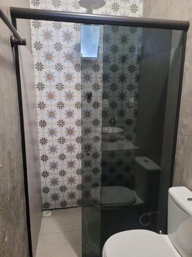 a bathroom with a glass shower with a toilet at Casa de Campo Pampulha in Belo Horizonte