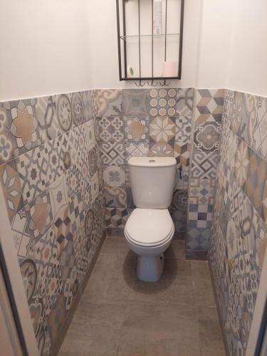 La salle de bains est pourvue de toilettes, d'un miroir et de carrelage. dans l'établissement Villas Floryanne - bassin arcachon, à Audenge