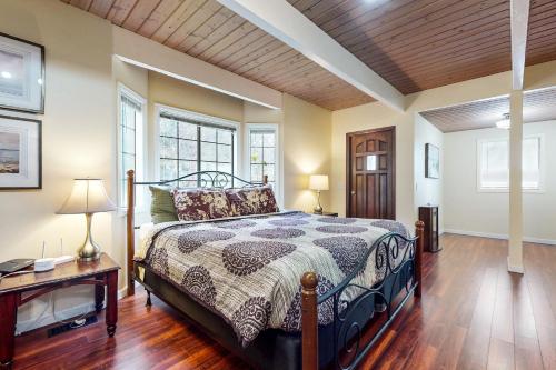 a bedroom with a bed and a desk and windows at West Beach Waterview in Oak Harbor