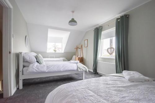 ein Schlafzimmer mit zwei Betten und einem Fenster in der Unterkunft Serenity House, Whitehall Ballycastle in Ballycastle