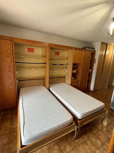 Ce lit se trouve dans un dortoir doté d'armoires en bois. dans l'établissement Studio avec Jardin, à Gréoux-les-Bains