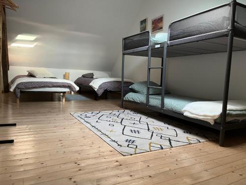 Cette chambre comprend 3 lits superposés et un tapis. dans l'établissement La maison de la Terre d Opale, à Saint-Inglevert