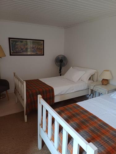 a bedroom with two beds and a desk with a fan at Country house Quinta da Salgueira in Alijó