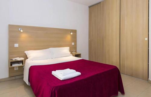 une chambre avec un grand lit avec deux serviettes dessus dans l'établissement Appartement T2 vue mer sur le port de Solenzara, à Kamiesch