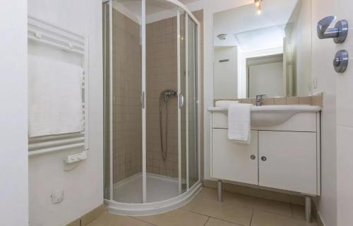 une salle de bain avec une douche en verre et un lavabo dans l'établissement Appartement T2 vue mer sur le port de Solenzara, à Kamiesch