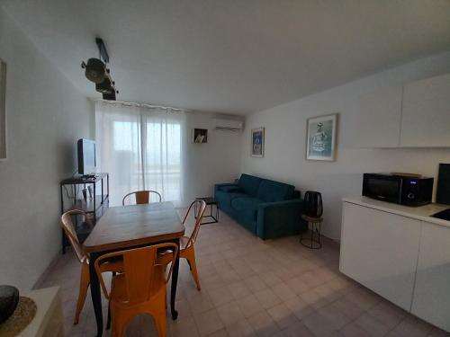 sala de estar con mesa y sofá verde en SèteÔSoleil, en Sète