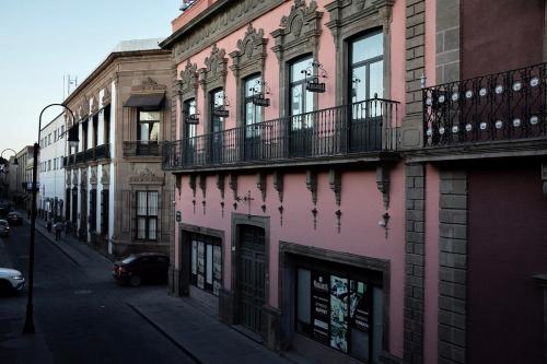 a pink building on the side of a street at Rincón Aranzazú Breakfast & Terrace in San Luis Potosí