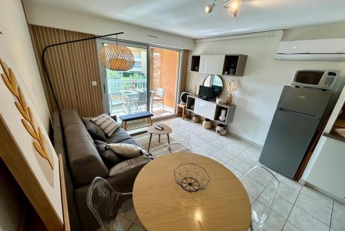 un salon avec un canapé et une table dans l'établissement Bedroom Apartment in Le Lavandou Pool Parking, au Lavandou