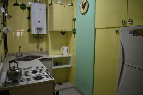 a kitchen with a stove and a sink and a refrigerator at Departamento Frente al Mar in Necochea