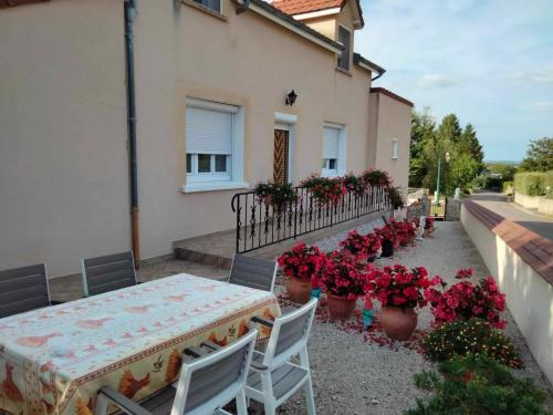 a table and chairs on a patio with flowers at Demeure des Lions in Bouzeron