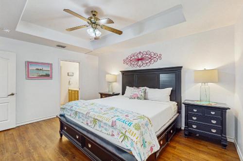 Un dormitorio con una cama y un ventilador de techo. en Beauty by the Bay, en Corpus Christi