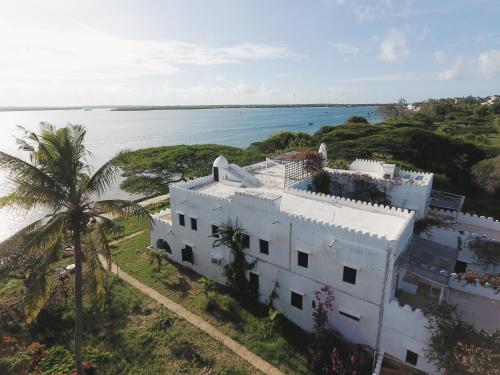 an aerial view of a white house with a palm tree at Marquezy House - Shela, Lamu Island in Shela