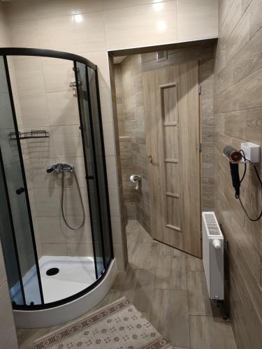 a bathroom with a shower with a glass door at Apartamenty Ustroń in Ustroń