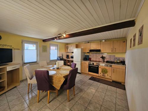 a kitchen with a table and chairs and a kitchen with at Ferienwohnungen Ober-Mörlen in Ober-Mörlen