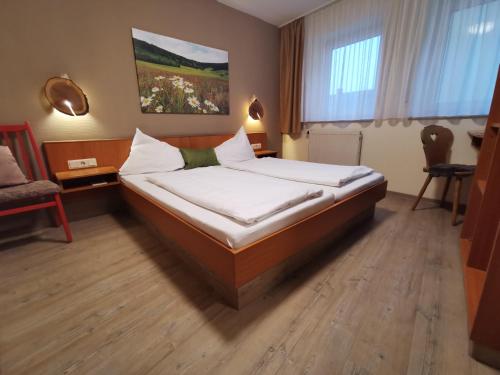 a bedroom with a bed with white pillows on it at Gasthaus & Hotel Drei Lilien in Werbach