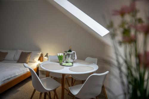 a white table and chairs in a room with a bed at Rodinný hotel Myslivna in Třeboň