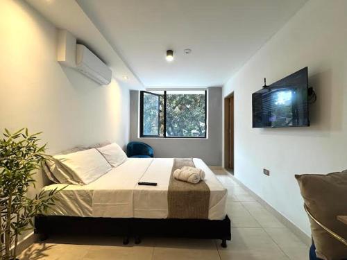 a bedroom with a bed and a television in it at Urbanity Living in Medellín