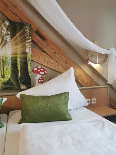 a bed with a green pillow in a room at Gasthaus & Hotel Drei Lilien in Werbach