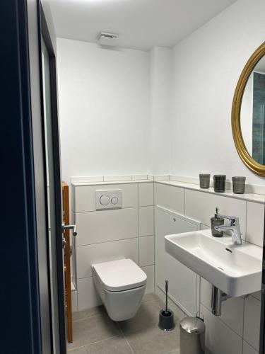 a white bathroom with a toilet and a sink at Bei Haags in Gommersheim