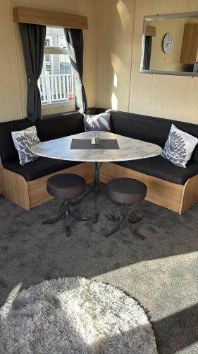 a living room with a couch with a table and two chairs at 15 Maple Rise in Gristhorpe