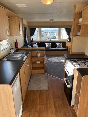 an rv kitchen with a stove and a couch at 15 Maple Rise in Gristhorpe