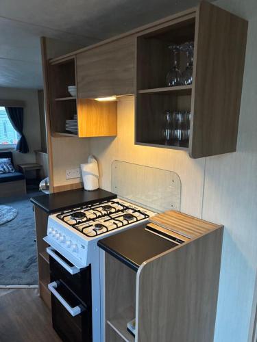 a kitchen with an oven and a stove top at 15 Maple Rise in Gristhorpe