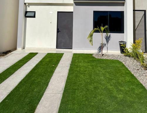 einen Hof mit grünem Gras und einem Haus in der Unterkunft Refugio Perfecto con Alberca y seguridad Cerca Galerías! in Mazatlán