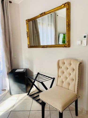 a mirror and a chair in a room at Residence Villa Margherita WITH POOL & HYDROMASSAGE in Cannobio