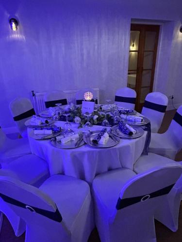 a long table with white tables and chairs in a room at Annandale Arms Hotel in Moffat