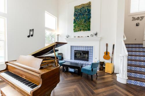 a living room with a piano and a fireplace at Vineyard estate with pool and amazing views in Yucaipa