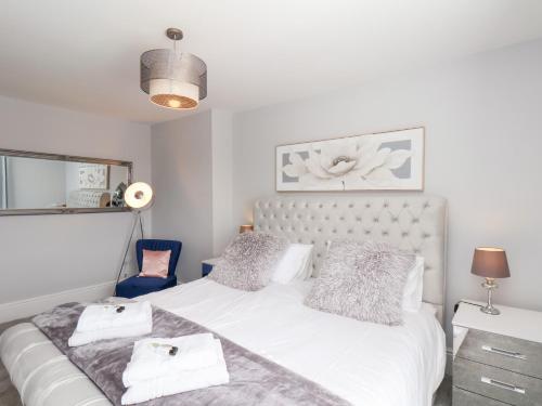 a bedroom with a white bed and a blue chair at Harpham Manor House in Lowthorpe