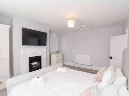 a white living room with a white couch and a fireplace at Harpham Manor House in Lowthorpe