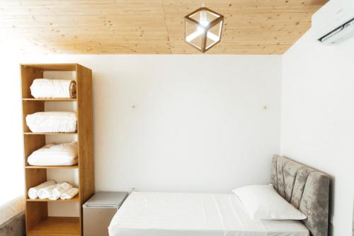 a room with a bed and a shelf with towels at Malibu Spille in Spille