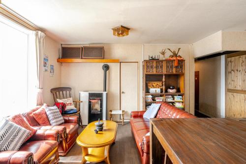 a living room with leather couches and a table at Togari Inn Suites in Iiyama