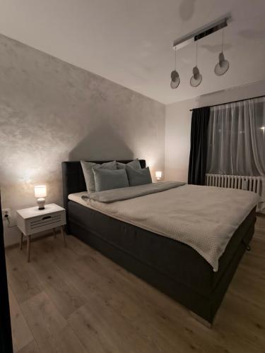 Un dormitorio con una cama grande con dos lámparas encima. en Apartment I&M, en Osijek