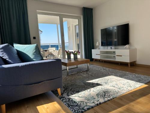 a living room with a couch and a tv at Sandbank Hotel & Appartements Lubmin in Lubmin