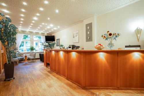 a salon with a wooden reception desk in a room at Komfort Hotel Am Kurpark in Bad Homburg vor der Höhe