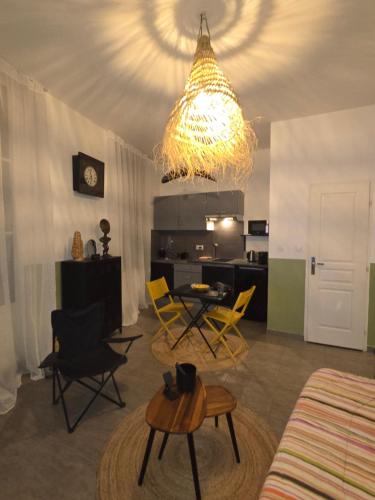 un salon avec des chaises jaunes et un lustre dans l'établissement Toulon centre studio, à Toulon