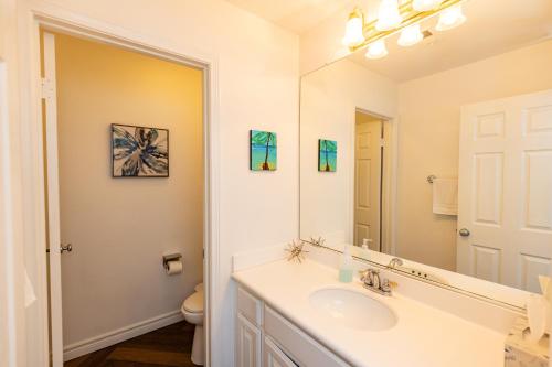 a white bathroom with a sink and a mirror at Vineyard estate with pool and amazing views in Yucaipa