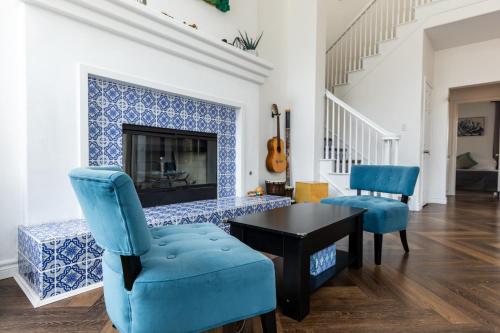 a living room with blue chairs and a fireplace at Vineyard estate with pool and amazing views in Yucaipa