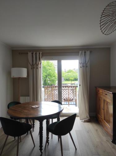 une salle à manger avec une table et des chaises et une fenêtre dans l'établissement Apt calme, proche hôpital, centre ville, à Brive-la-Gaillarde