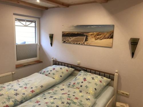 Un dormitorio con una cama y un cuadro en la pared. en Holiday apartment Utholm, en Tönning