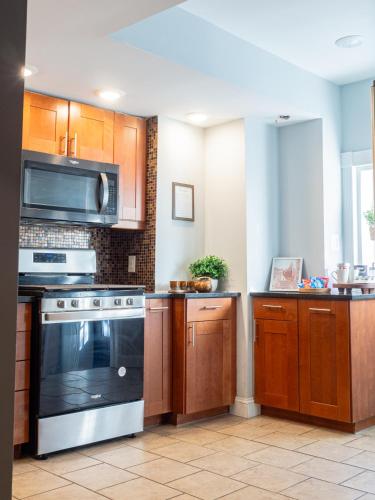 a kitchen with wooden cabinets and a stove at Historic Townhouse - Heart of Little Italy in Baltimore