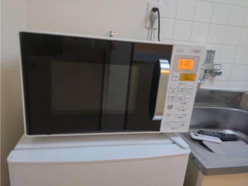 a microwave oven sitting on top of a kitchen counter at IshinomakiYado - Vacation STAY 71853v in Ishinomaki