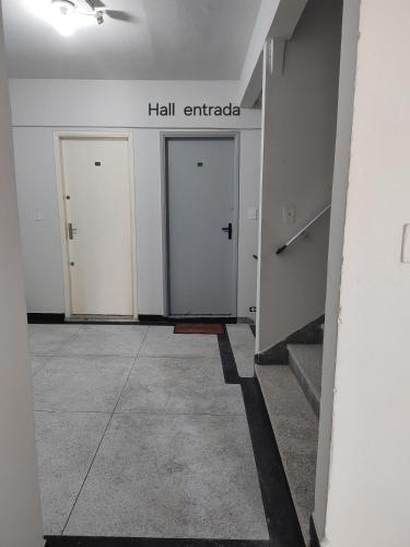 a hallway with three white doors in a building at Kitnet pé na areia - Mirim - PG in Praia Grande