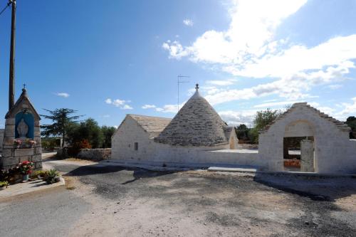 a church with a stone building and a tower at Agriturismo L'Aire Alberobello in Alberobello