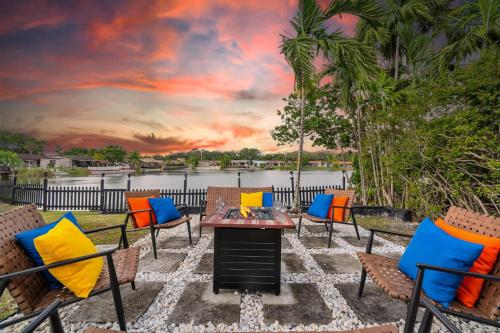 a patio with chairs and a table with a sunset at Lakefront Retreat Perfect for Family Fun in Miami